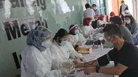 Pedagang menjalani penapisan kesehatan saat vaksinasi COVID-19 di Pasar Tanah Abang Blok A, Jakarta, Rabu (17/2/2021). Total sasaran vaksinasi tahap kedua ini mencapai 38.513.446 yang terdiri dari 21 juta lebih lansia, dan hampir 17 juta untuk pekerja pelayanan publik. (Liputan6.com/Herman Zakharia)