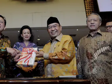Ketua DPD RI Irman Gusman (kiri) menerima buku ikhtisar hasil pemeriksaan semester ll tahun 2014 dari Ketua BPK RI Harry Azhar Aziz (kedua kanan) usai mengikuti Rapat Paripurna di Komplek Parlemen, Jakarta, Rabu (8/4/2015). (Liputan6.com/Andrian M Tunay)
