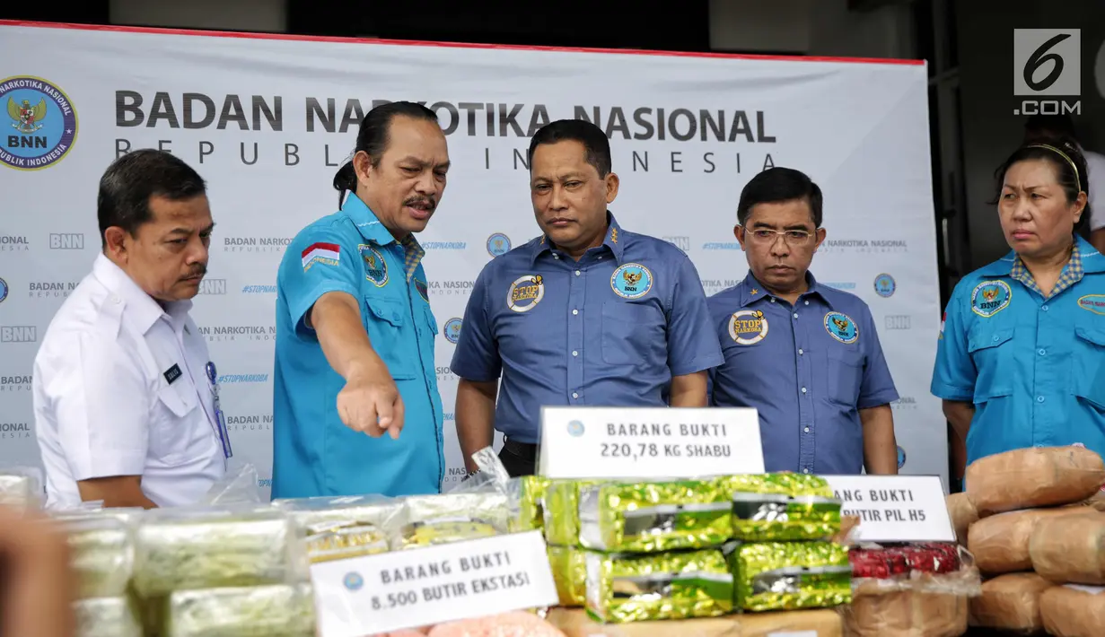 Kepala BNN Komjen Budi Waseso mendengarkan penjelasan terkait rilis pengungkapan peredaran narkotika di Jakarta, Kamis (9/11). Petugas menyita 220 kg sabu, ribuan pil ekstasi, serta pil happy five dari jaringan Malaysia-Aceh. (Liputan6.com/Faizal Fanani)