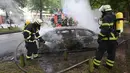 Petugas pemadam kebakaran memadamkan api sebuah mobil yang hangus terbakar usai aksi demo menentang KTT G20 di Hamburg, Jerman utara, (7/7). (Bodo Marks / dpa via AP)