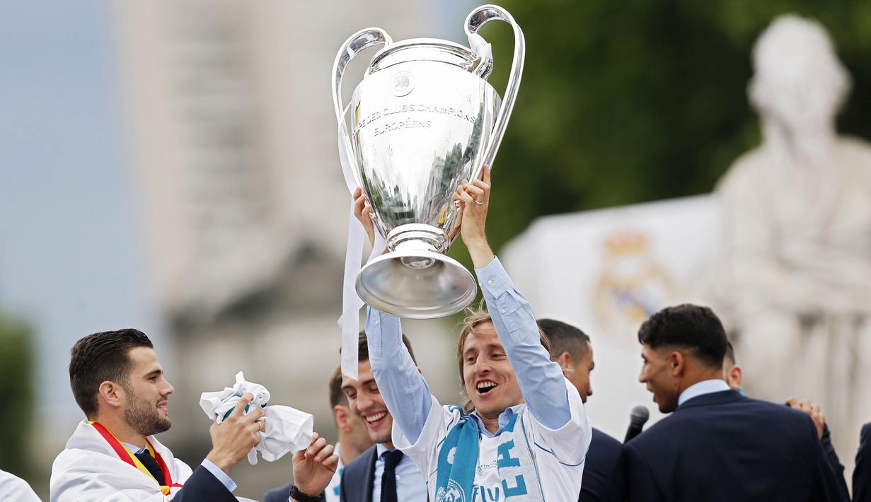 Gelandang Real Madrid, Luka Modric, mengangkat trofi Liga Champions di Monumen Cibeles, Madrid, Minggu (27/5/2018). Real Madrid menggelar pawai kemenangan bersama fans usai menjuarai Liga Champions 2018. (AP/Francisco Seco)