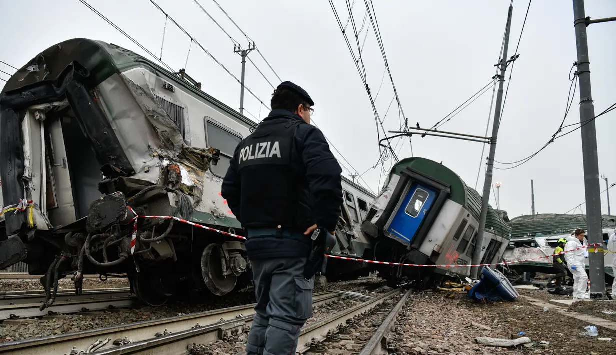 Seorang polisi Italia berjaga di lokasi di lokasi tergelincirnya kereta di Stasiun Pioltello Limito, Milan, Italia, Kamis (25/1). Belum diketahui penyebab kecelakaan tersebut. (AFP PHOTO/Piero CRUCIATTI)