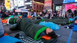 Para aktivis menggelar aksi dengan beralaskan kantong tidur. (KENA BETANCUR/AFP)
