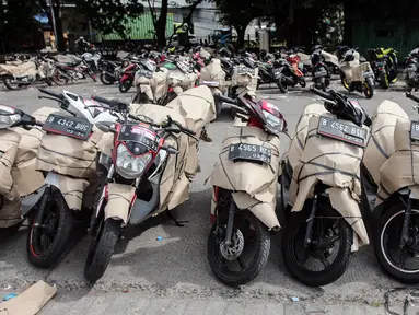 Pekerja mendata sepeda motor milik peserta program mudik motor gratis (Motis) Lebaran 2023 di kawasan Stasiun Jakarta Gudang, Kampung Bandan, Jakarta, Minggu (16/4/2023). (Liputan6.com/Johan Tallo)