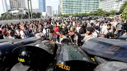 Untuk mencegah aksi massa meluas, petugas kepolisian membuat barisan blokade saat menggelar simulasi pengamanan Pemilu Presiden 2014 di Bundaran HI, Jakarta, (29/5/2014). (Liputan6.com/Faizal Fanani)