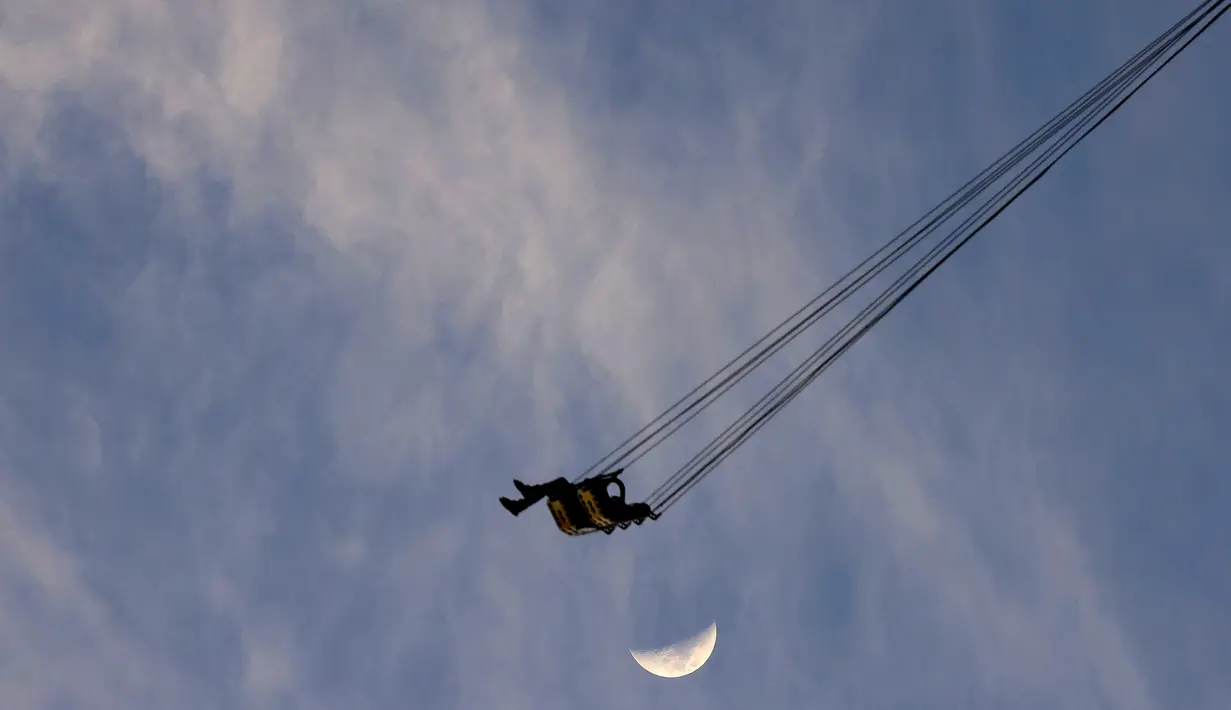 Pengunjung menaiki wahana ontang-anting Sky Flyer atau di Taman Bollywood, Dubai, Uni Emirat Arab (18/2/2021).  Ontang-anting bernama Bollywood Skyflyer tersebut terbuat dari 421 ton baja, membutuhkan waktu 600 hari untuk dibangun, dan 120 hari untuk dipasang. (AFP/ Giuseppe Cacae)