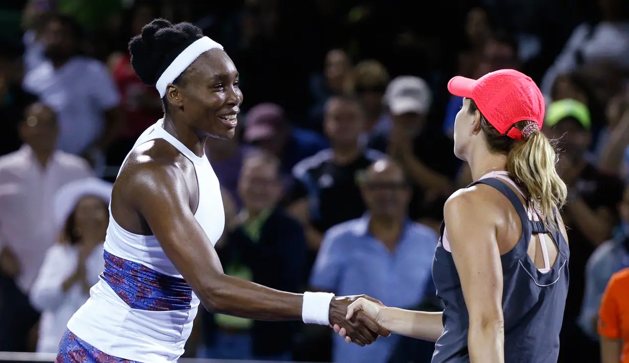 Petenis putri AS, Venus Williams berjabat tangan dengan petenis senegaranya, Danielle Collins seusai babak perempat final Miami Terbuka 2018 di Crandon Park, Kamis (29/3). Venus gagal maju lebih jauh setelah bertarung selama 87 menit. (AP/Wilfredo Lee)