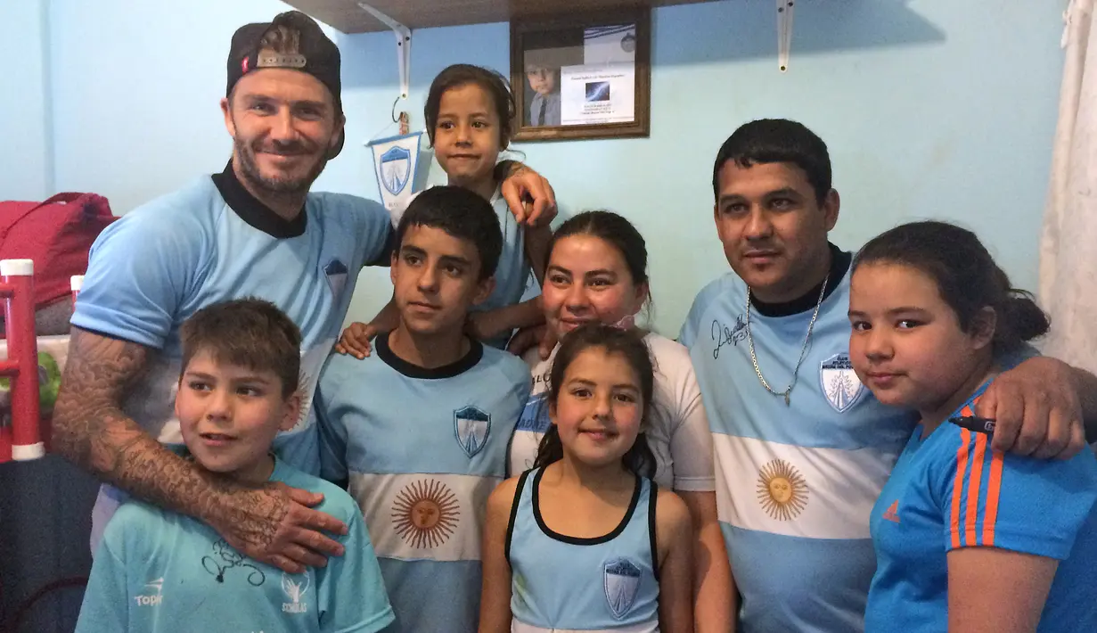 Mantan kapten Timnas Inggris, David Beckham berpose dengan anak-anak di kawasan pemukiman kumuh 1-11-14 di Buenos Aires, Senin (9/11/2015). Beckham berada Argentina untuk membuat film dokumenter tentang sepak bola. (AFP/FIXER-Argentina/Macarena GAGLIARD)