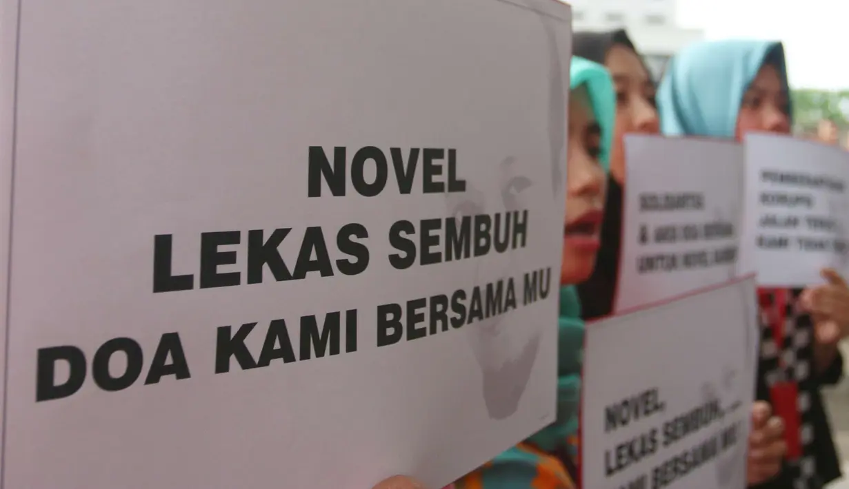 Sejumlah orang membawa poster ungkapan kepedulian saat mengikuti aksi peringatan 100 hari penyerangan Novel Baswedan di gedung KPK, Jakarta, Kamis (20/7). (Liputan6.com/Helmi Afandi)
