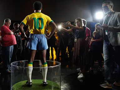 Wartawan mengambil gambar patung pemain sepak bola legendaris Brasil, Pele, di Museum Tim Sepak Bola Brasil di Rio de Janeiro, Kamis (20/2/2020). Konfederasi Sepak Bola Brasil meluncurkan patung Pele sebagai bagian dari peringatan 50 tahun sejak kemenangan Piala Dunia 1970. (AP/Leo Correa)