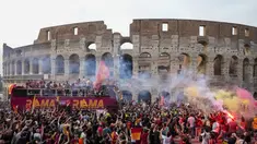 Bus tim AS Roma melaju di tengah kerumunan pendukung yang bergembira saat merayakan kemenangan juara Liga Konferensi Eropa UECL di depan Colosseum di Roma (26/5/2022). AS Roma menjuarai Konferensi Eropa UECL setelah mengalahkan Fayenoord dengan skor tipis 1-0. (AP Photo/Gregorio Borgia)