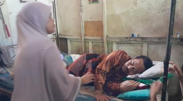 Nur Hayik (67)  tergolek lemah mengalami luka bacok senjata tajam. (Hermawan Arifianto/Liputan6.com)