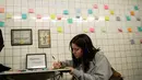 Alma Berti menulis pesan di selembar post-it sebagai bagian dari 'subway therapy' di dinding stasiun Union Square, New York, Kamis (10/11). Kegiatan ini menjadi semacam terapi bagi warga yang ingin melepaskan emosi mereka. (DREW ANGERER/AFP)