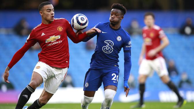 Penyerang Manchester United, Mason Greenwood, berebut bola dengan pemain Chelsea, Callum Hudson-Odoi, pada laga Liga Inggris di Stadion Stamford Bridge, Minggu (28/2/2021). Kedua tim bermain imbang 0-0. (AP/Ian Walton, Pool)