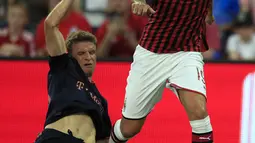 Striker Bayern Munchen, Thomas Muller berusaha merebut bola bek AC Milan, Theo Hernandez selama pertandingan International Champions Cup 2019 di Kansas City, Amerika Serikat (24/7/2019). AC Milan kalah tipis 1-0 atas Munchen berkat gol Leon Goretzka. (AP Photo/Orlin Wagner)