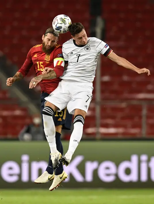 Bek Spanyol Sergio Ramos berebut bola udara dengan  gelandang Jerman Julian Draxler pada pertandingan UEFA Nations League di Stuttgart, Jerman (3/9/2020). Jerman bermain imbang 1-1 atas Spanyol. (AFP Photo/Thomas Kienzle)