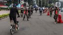 Satpol PP menghentikan pesepeda yang tidak mengenakan masker dengan benar di kawasan Bundaran HI, Jakarta, Minggu (17/1/2021). Pemerintah terus melakukan berbagai upaya guna mencegah penyebaran COVID-19 dan menurunkan angka masyarakat yang terpapar virus corona. (Liputan6.com/Johan Tallo)