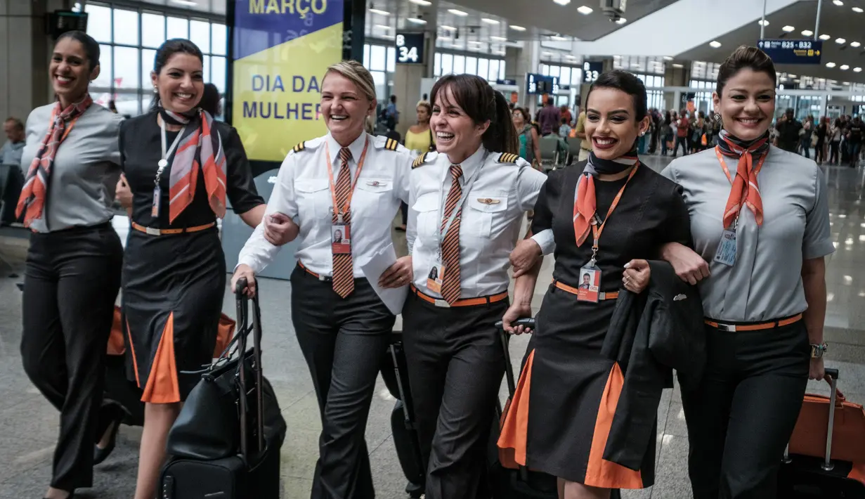 Awak maskapai penerbangan GOL Airlines saat berada di Bandara Internasional Tom Jobim, Rio de Janeiro, Brasil (8/3). Memperingati Hari Perempuan Internasional, GOL Airlines menghadirkan seluruh awak adalah wanita. (AFP PHOTO / Yasuyoshi Chiba)