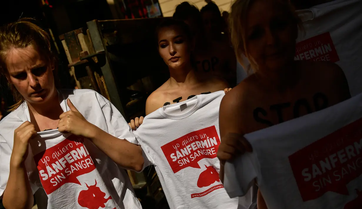 Para aktivis mengenakan kaos bertuliskan, '' I want a San Fermin without blood" selama unjuk rasa memprotes adu banteng dalam Festival San Fermin di depan Balai Kota di Pamplona, Spanyol utara, (5/7). (AP Photo/Alvaro Barrientos)
