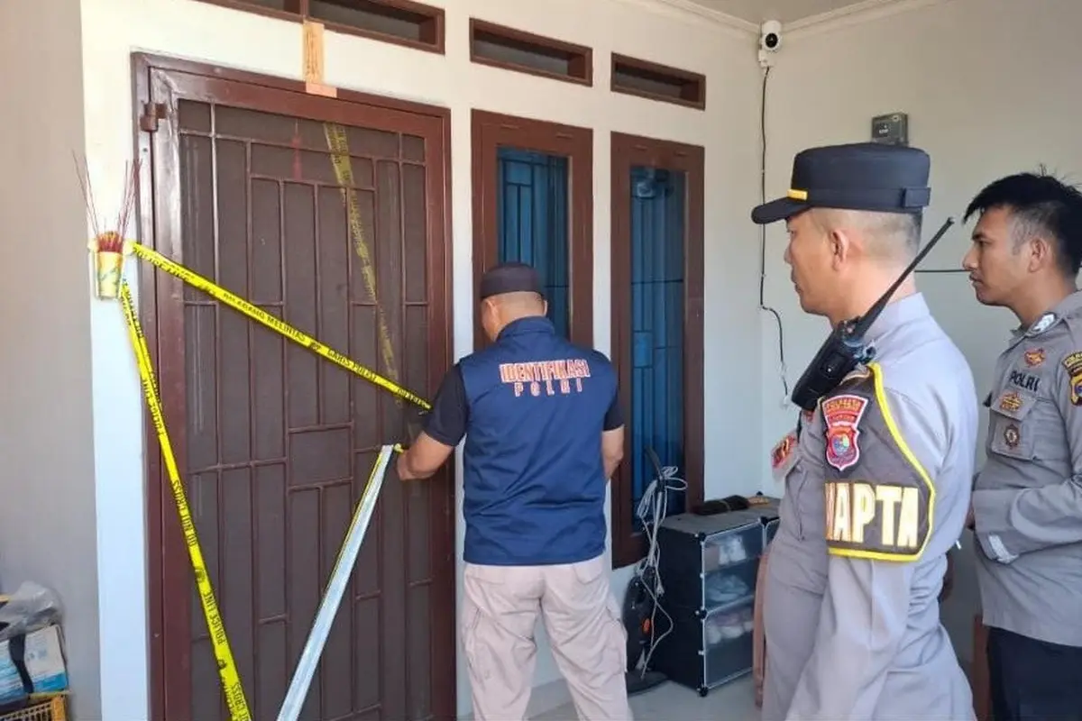 Petugas Kepolisian dari Polresta Bandar Lampung memasang garis polisi di rumah seorang karyawati biro jasa yang diduga jadi korban pembunuhan (Liputan6.com/Ardi Munthe)
