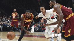 Pemain Cleveland Cavaliers, Kyrie Irving (kiri) berusaha mengejar bola bersama pemain Portland Trail Blazers, C.J. McCollum pada laga NBA basketball game di oda Center, Portland (11/1/2016). Blazers menang 102-86.  (AP/Steve Dykes)