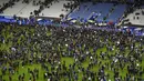 Suporter sepak bola berkumpul di lapangan menunggu izin keamanan untuk meninggalkan Stade de France di Saint-Denis, Paris, (13/11). Dikabarkan ada 140 orang tewas dalam aksi teroris di dekat stadion Stade de France. (AFP PHOTO/FRANCK FIFE)