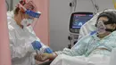 Seorang wanita mendapat suntikan di ruang gawat darurat yang berubah menjadi unit COVID-19 di rumah sakit Bagdasar-Arseni, Bucharest, Selasa (12/10/2021). Rumania pada Selasa mencatatkan jumlah tertinggi infeksi corona dan kematian dalam sehari sejak pandemi dimulai (AP Photo/Andreea Alexandru)