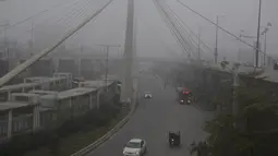 Kendaraan melaju di sebuah jalan di tengah kabut tebal di Kota Lahore, Pakistan timur, pada 13 Desember 2020. Kabut tebal menyelimuti sejumlah kota di Pakistan, sehingga meminimalkan jarak pandang dan mengganggu lalu lintas jalan. (Xinhua/Sajjad)
