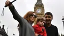 Pengunjung berswafoto dengan latar belakang menara jam Big Ben yang mulai membisu di Elizabeth Tower, London, Senin (21/8). Menara Big Ben akan menjalani renovasi yang diperkirakan menghabiskan dana sekitar hampir Rp500 miliar. (BEN STANSALL / AFP)