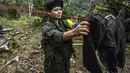 Seorang gerilyawati Pasukan Bersenjata Revolusioner Kolombia (FARC) menjemur pakaian di kamp Magdalena Medio, Kolombia (15/3/2016). Gerilyawati FARC dikenal lebih sadis terhadap musuh daripada pasukan gerilyawan. (AFP Photo/Luis Acosta)
