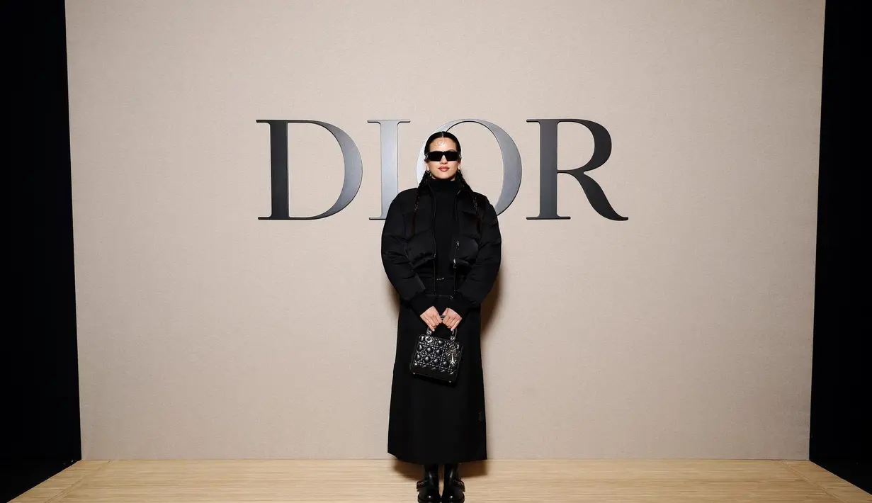 Rosalia terlihat cool dengan coat hitam dan rok panjang wol. Dipadukan dengan Lady Dior Bag, sunglasses dan boots [Dior]