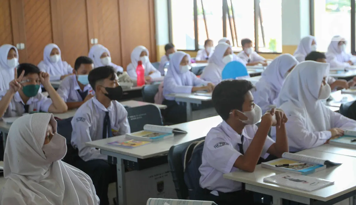 Siswa mengikuti kegiatan belajar mengajar pada hari pertama pembelajaran tatap muka di SMP 26 Depok, Depok, Jawa Barat, Senin (24/1/2022). Pemerintah Kota Depok mulai menggelar Pembelajaran Tatap Muka (PTM) secara penuh atau 100 persen mulai hari ini. (Liputan6.com/Herman Zakharia)