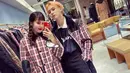 HyunA dan DAWN tampil serasi kenakan puffer jacket motif plaid warna merah. (Instagram/hyunah_aa).