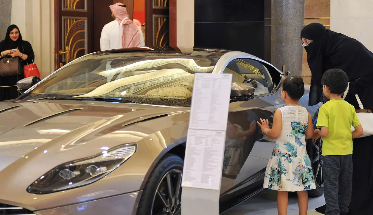 Wanita Saudi melihat sebuah mobil di sebuah pameran mobil di resor Jeddah Laut Merah Jeddah (5/10).Walau peraturan tersebut akan berlaku pada 24 Juni 2018, para wanita Saudi mulai berburu mobil impiannya. (AFP Photo/Amer Hilabi)
