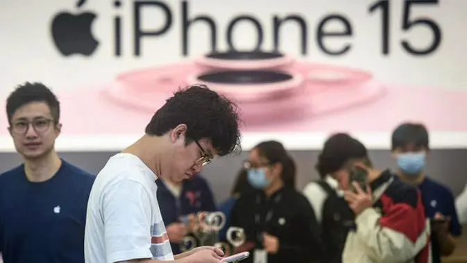 Seorang pria mencoba ponsel iPhone 15 yang baru saja diluncurkan di sebuah toko Apple di Hangzhou, di provinsi Zhejiang, China pada 22 September 2023. (AFP/China OUT) (© 2025 Liputan6.com)