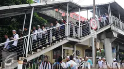 Peserta aksi 2 Desember menuruni jembatan penyeberangan orang (JPO) di kawasan Pasar Baru, Jakarta, Jumat (2/12). Peserta aksi pulang dengan tertib usai melaksanakan Salat Jumat. (Liputan6.com/Helmi Afandi)