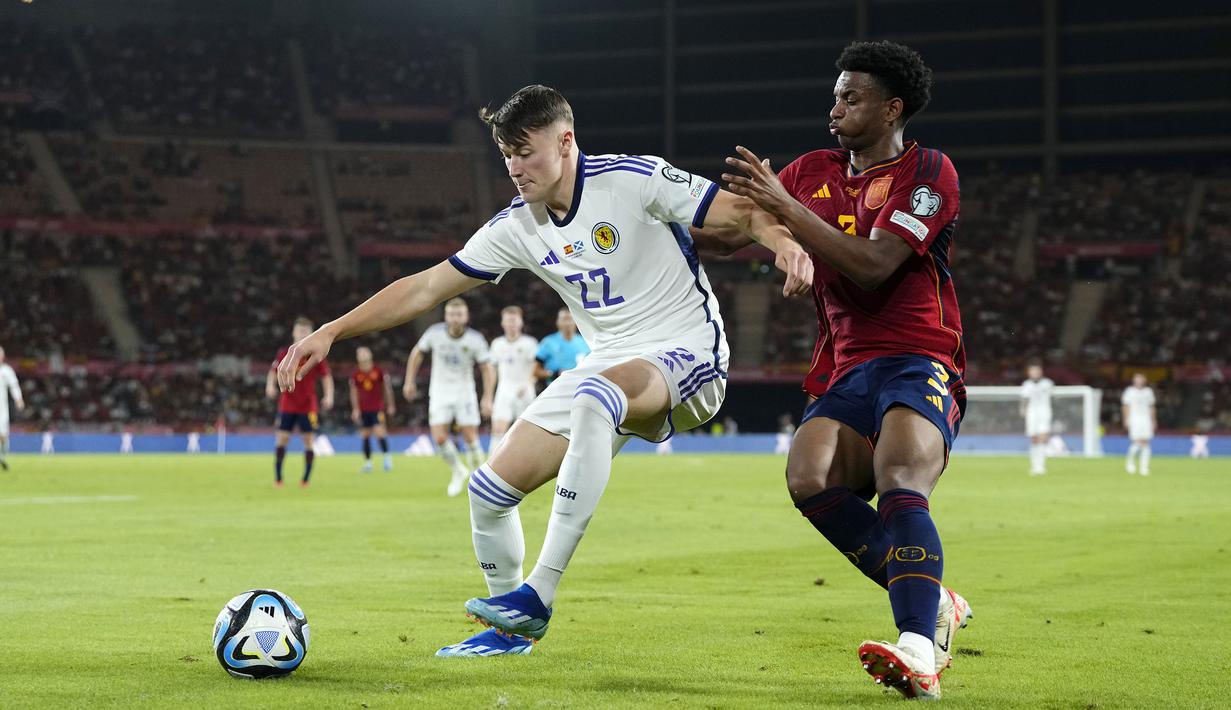 Pemain Spanyol, Alejandro Balde (kanan) berusaha merebut bola dari pemain Skotlandia, Nathan Patterson pada laga Grup A Kualifikasi Euro 2024 di La Cartuja Stadium, Sevilla, Spanyol, Jumat (13/10/2023) dini hari WIB. (AP Photo/Jose Breton)