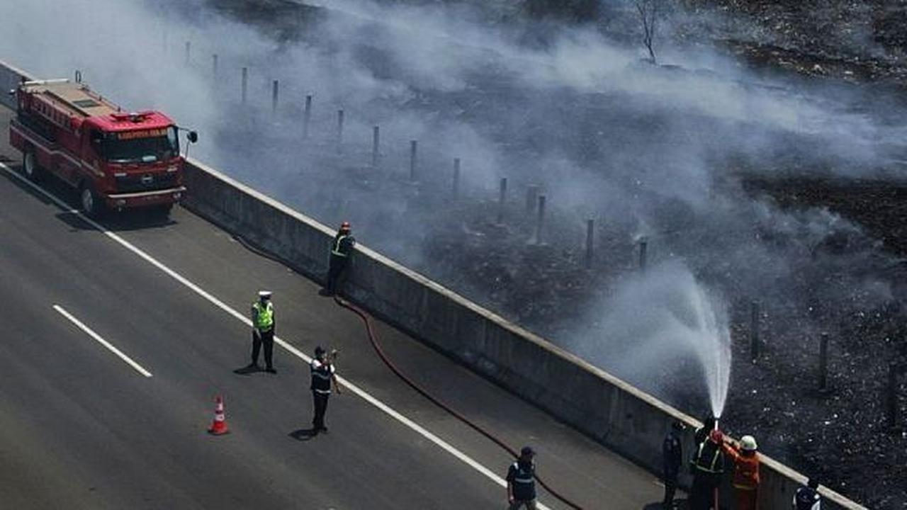 Petugas gabungan saat melakukan pemadaman  asap sisa kebakaran TPS Ilegal di samping Tol Cibitung-Cilincing.
