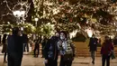 Orang-orang berfoto di alun-alun Syntagma yang diterangi dekorasi Natal di pusat kota Athena, Yunani pada 21 Desember 2020. Yunani akan merayakan musim Natal di bawah langkah-langkah penguncian wilayah atau lockdown COVID-19 hingga 7 Januari 2021 mendatang. (LOUISA GOULIAMAKI/AFP)