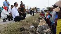 Presiden Joko Widodo berjongkok dan berbincang dengan buruh yang membangun talud desa di Grobogan. (foto: Liputan6.com/felek wahyu)