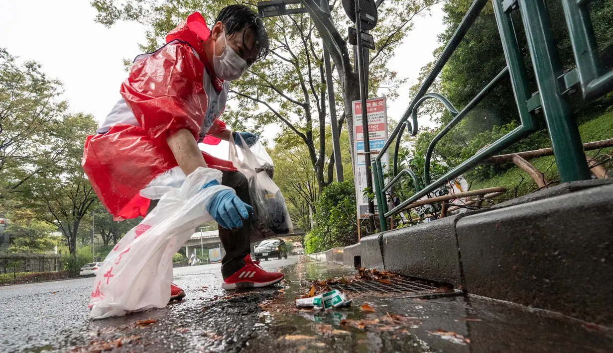 Seorang peserta memungut sampah dari jalan selama tahap Jepang "SpoGOMI World Cup 2023" di mana para tim memungut sampah sebanyak mungkin, di daerah Shinjuku, Tokyo pada tanggal 9 Oktober 2023. (Richard A. Brooks/AFP)