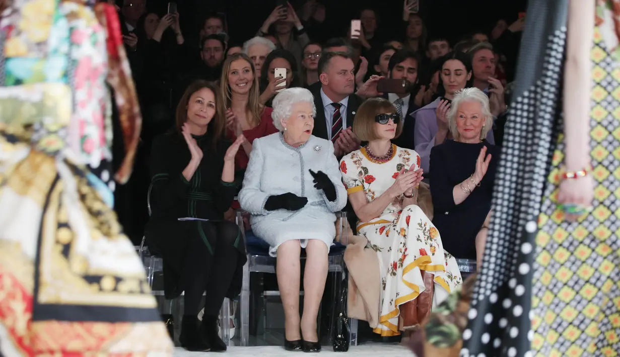 <p>Ratu Elizabeth II duduk di sebelah Anna Wintour dan chief executive British Fashion Council, Caroline Rush menyaksikan London Fashion Week 2018, Selasa (20/2). Ratu Elizabeth datang di hari terakhir London Fashion Week. (Yui Mok/Pool photo via AP)</p>