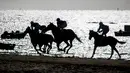Sejumlah joki memacu kuda mereka pada lomba pacuan kuda di sepanjang pantai di Sanlucar de Barrameda, Spanyol pada 11 Agustus 2019. Balap kuda di tepi pantai ini merupakan acara tahunan yang telag berlangsung selama lebih dari 140 tahun. (AP Photo/Javier Fergo)