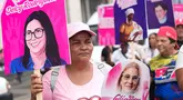 Seorang perempuan memegang poster bergambar mantan Ibu Negara Venezuela, Cilia Flores, saat mengikuti pawai yang diselenggarakan pemerintah untuk meningkatkan kesadaran tentang kanker payudara dalam rangka Bulan Peduli Kanker Payudara di Caracas, Venezuela, Kamis (22/10/2026). (AP Photo/Pedro Mattey)