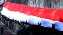 Anggota Brimob Polda Bali dan Basarnas mengibarkan Bendera Merah Putih di dinding tebing Pantai Pandawa, Badung, Bali, Senin (14/8). Pengibaran Bendera Merah Putih sepanjang 800 meter tersebut untuk memperingati HUT RI ke-72. (AP Photo/Firdia Lisnawati)