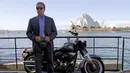 Arnold Schwarzenegger menggunakan kacamata sambil berpose di samping motor Harley saat mempromosikan film terbarunya, `Terminator Genisys` di depan Sydney Opera House di Australia, Kamis (4/6/2015). (REUTERS/David Gray)
