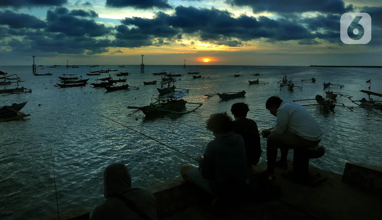 Warga memancing ikan saat matahari terbenam di Pantai Kedongnan, Bali, Senin (6/9/2021). Masa pandemi dimanfaatkan warga yang kehilangan pekerjaan untuk memancing, dimana hasilnya digunakan sebagai pelengkap lauk makan di rumah. (merdeka.com/Arie Basuki)