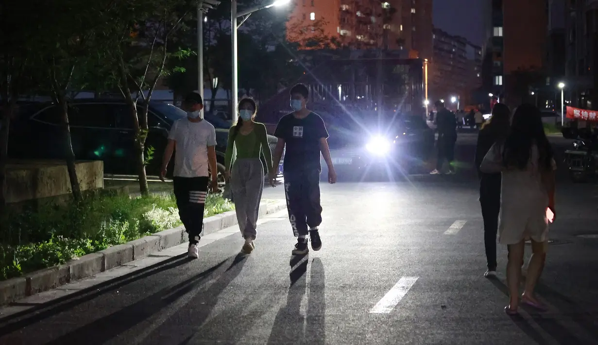 Warga berjalan di dalam komunitas perumahan di Shanghai (11/4/2022). Banyak penduduk di kota berpenduduk 26 juta itu telah dikurung di rumah hingga tiga minggu karena China mempertahankan strategi "nol-COVID" dalam menangani wabah dengan isolasi ketat dan pengujian massal. (AP Photo)