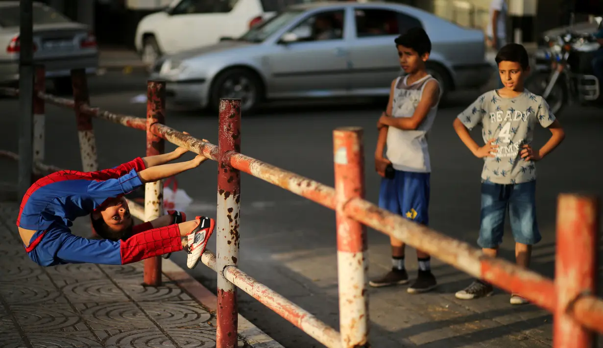 Kelenturan tubuh Mohammed al Sheikh saat menunjukkan aksinya di sebuah pantai di Kota Gaza, Palestina, Kamis (2/6). Anak laki-laki yang dijuluki Spiderboy ini mengundang perhatian masyarakat internasional karena kelenturan tubuhnya. (REUTERS/Mohammed Sale