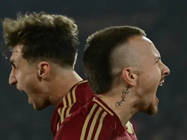 Pemain belakang AS Roma, Angelino (kanan) merayakan gol dengan rekan setimnya pada pertandingan leg pertama 16 besar Liga Europa 2024/2025 melawan Athletic Bilbao di Stadion Olimpico, pada Kamis 6 Maret 2025 waktu setempat atau Jumat (7/3/2025) dini hari WIB. (Filippo MONTEFORTE/AFP)